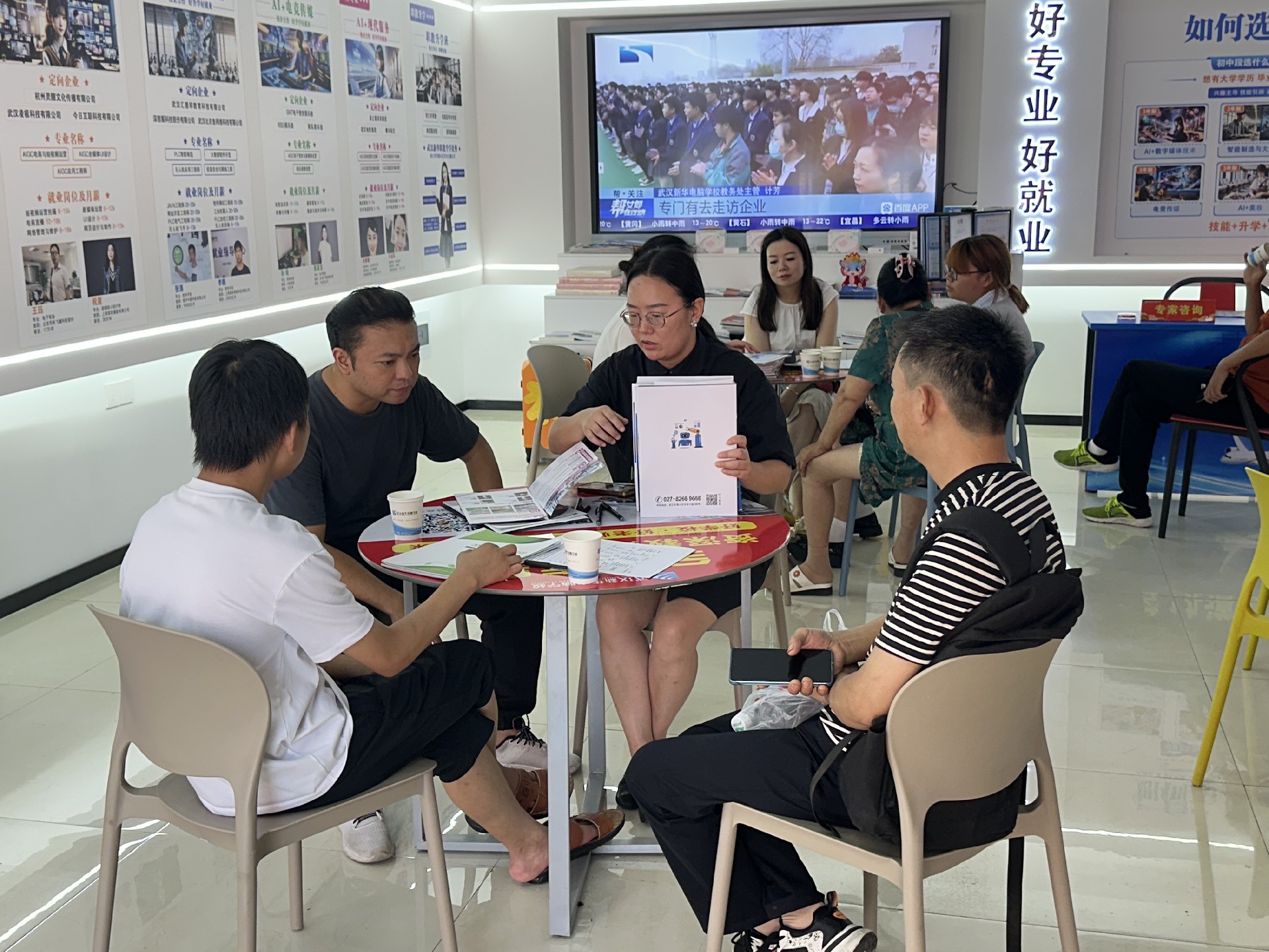 连日高温预警高悬，整座城市仿佛陷入巨大蒸笼。然而，比骄阳更灼热的，是武汉新华电脑学校招生咨询中心内持续升温的求学热情！咨询电话铃声此起彼伏，来访家长与学生络绎不绝，单日咨询量屡创新高，空调全力运转也难掩报名现场的热力四射！火热现场直击咨询台前人头攒动：专业咨询老师被热情的学生和家长层层围绕，耐心解答
